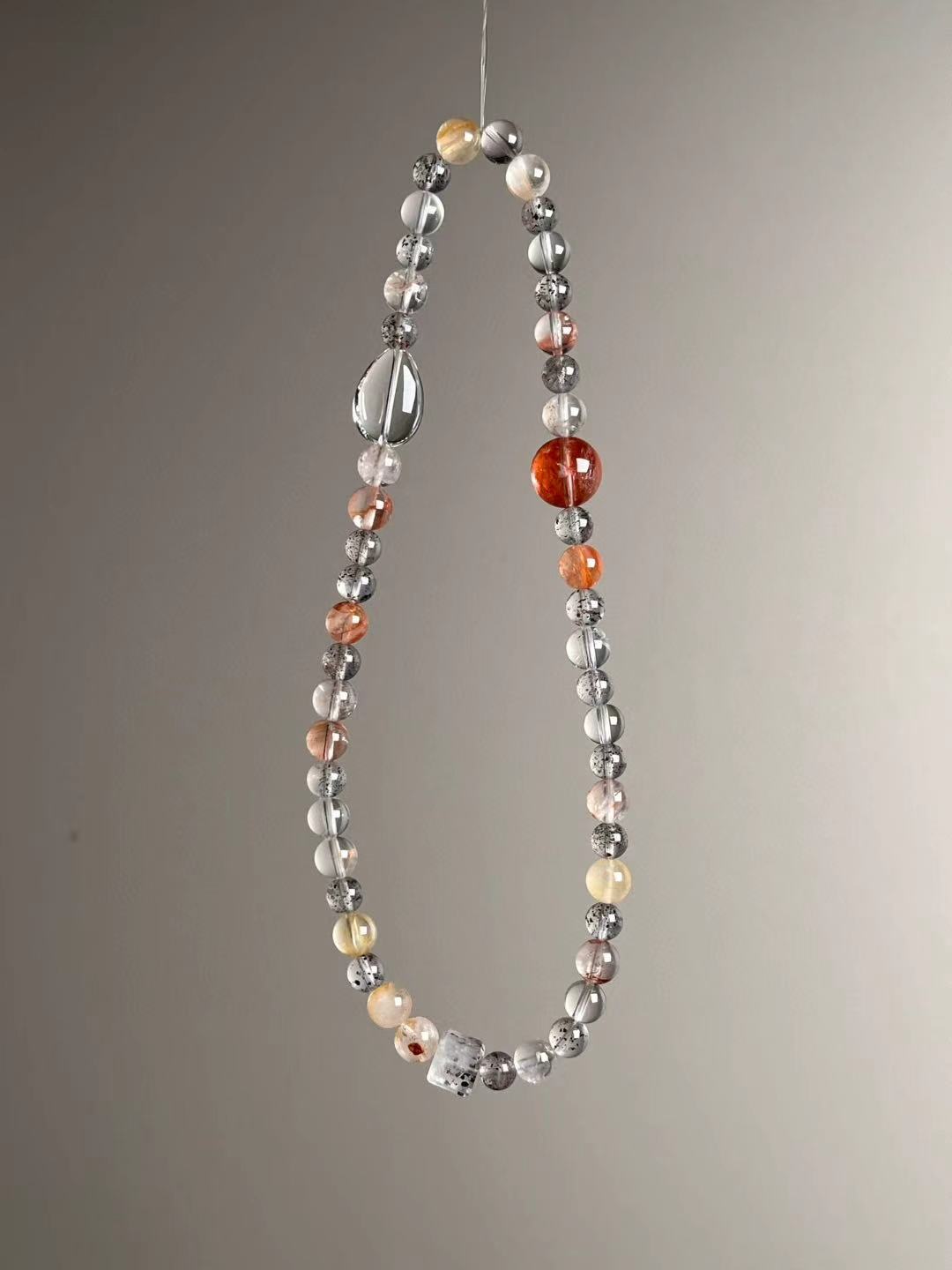 Flat lay — full strand showing alternating Black Strawberry Quartz, Clear Quartz, Garden Quartz and Super Seven cube.