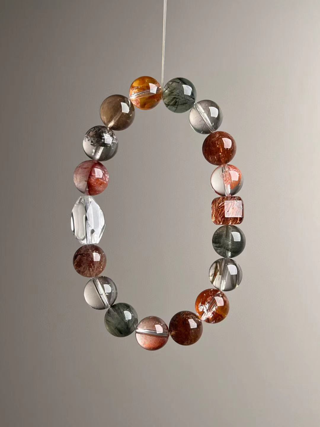Alternate orientation showing the Auralite-23/ghost-quartz blend and protective black-gold super seven; natural color variation visible.