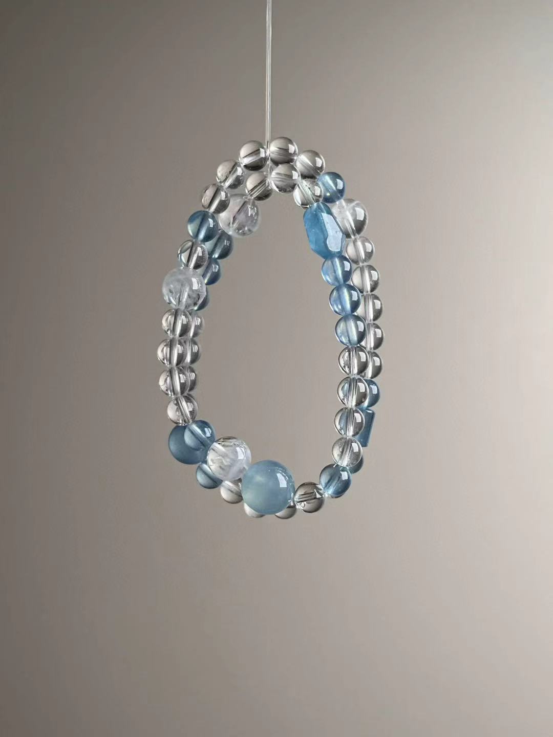 Side angle — faceted aquamarine centerpiece with white phantom accents and clear quartz.