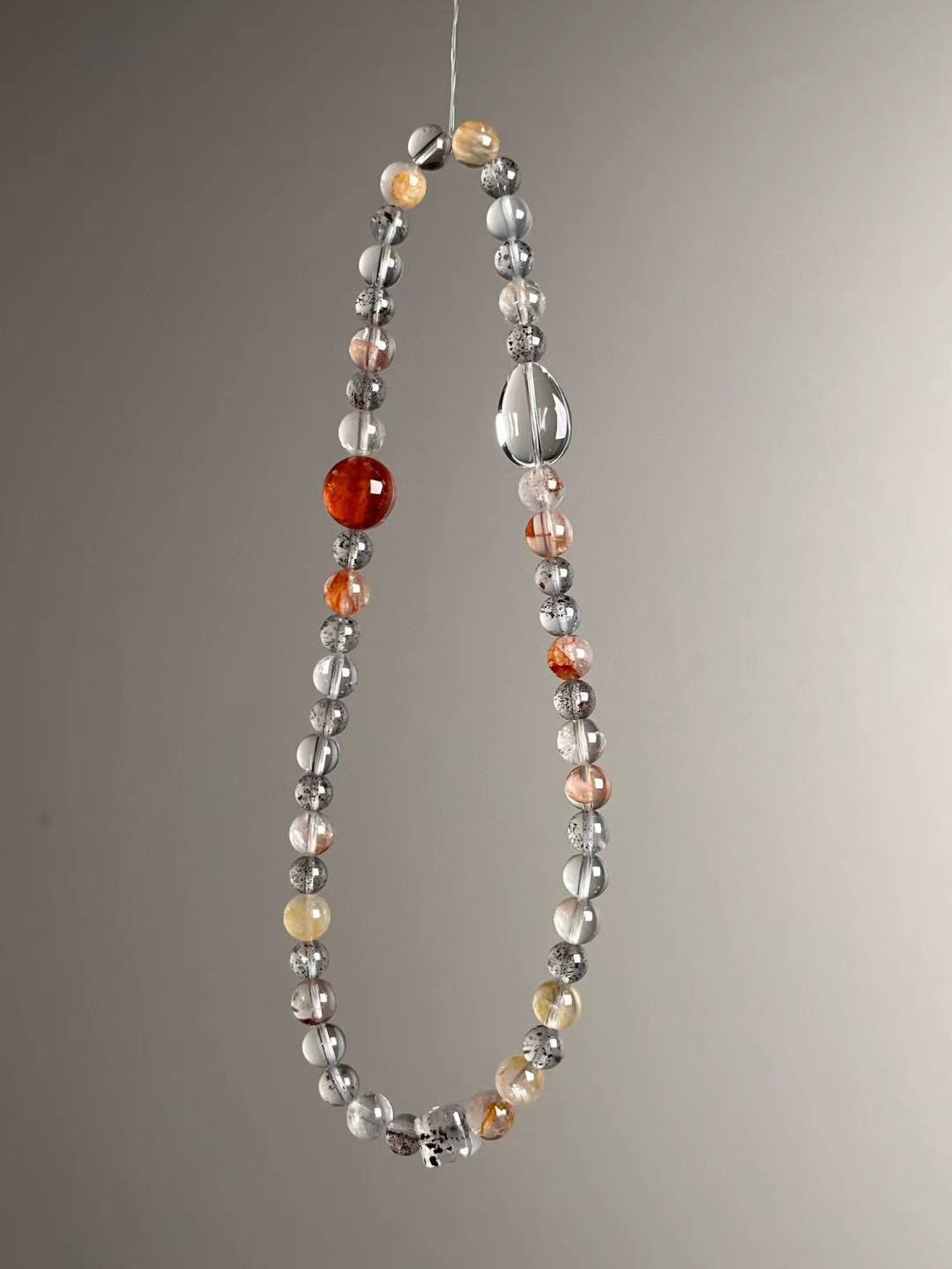 Side angle — fiery red Garden Quartz centerpiece with Clear Quartz and protective Black Strawberry Quartz.