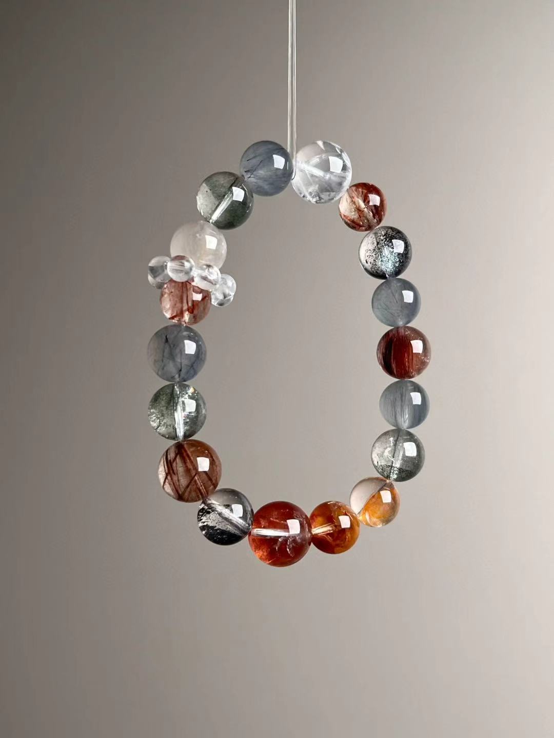 Flat lay — Black Super Seven and Copper Rutilated sequence with koi flower quartz; clear quartz cluster accent.