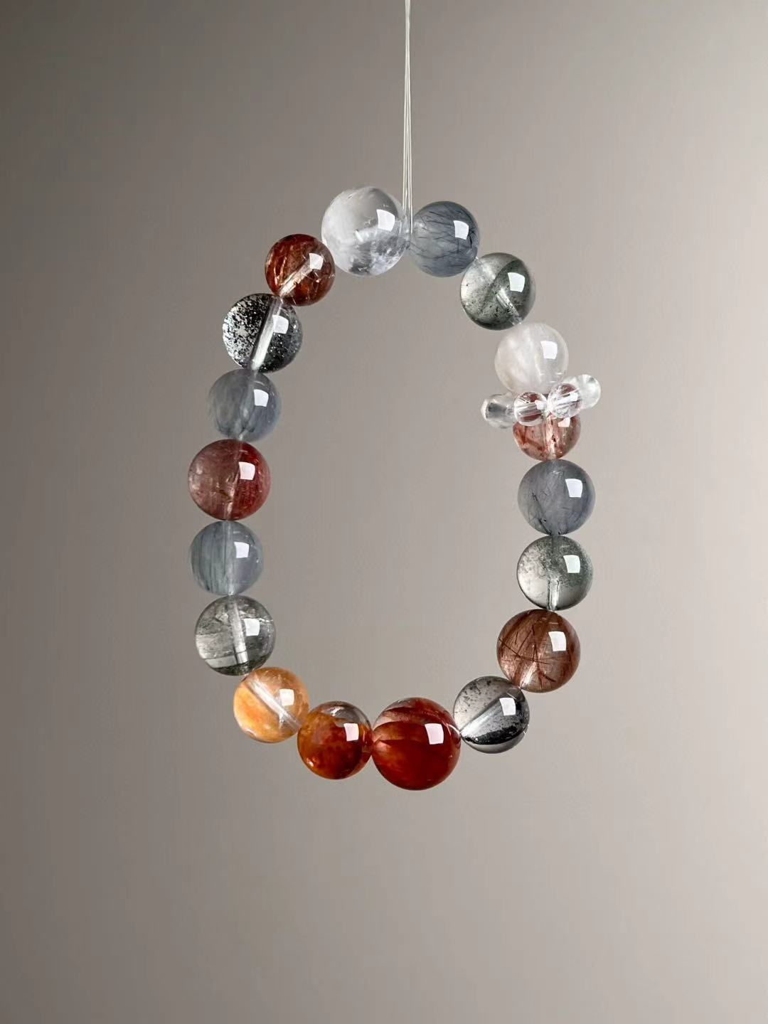 Catalog composite — gemstone callouts for Black Super Seven, Blue Rutilated Quartz, Green/White Phantom, Copper Rutilated Quartz, Goldstone, Koi Flower quartz and Gray Hair Quartz.