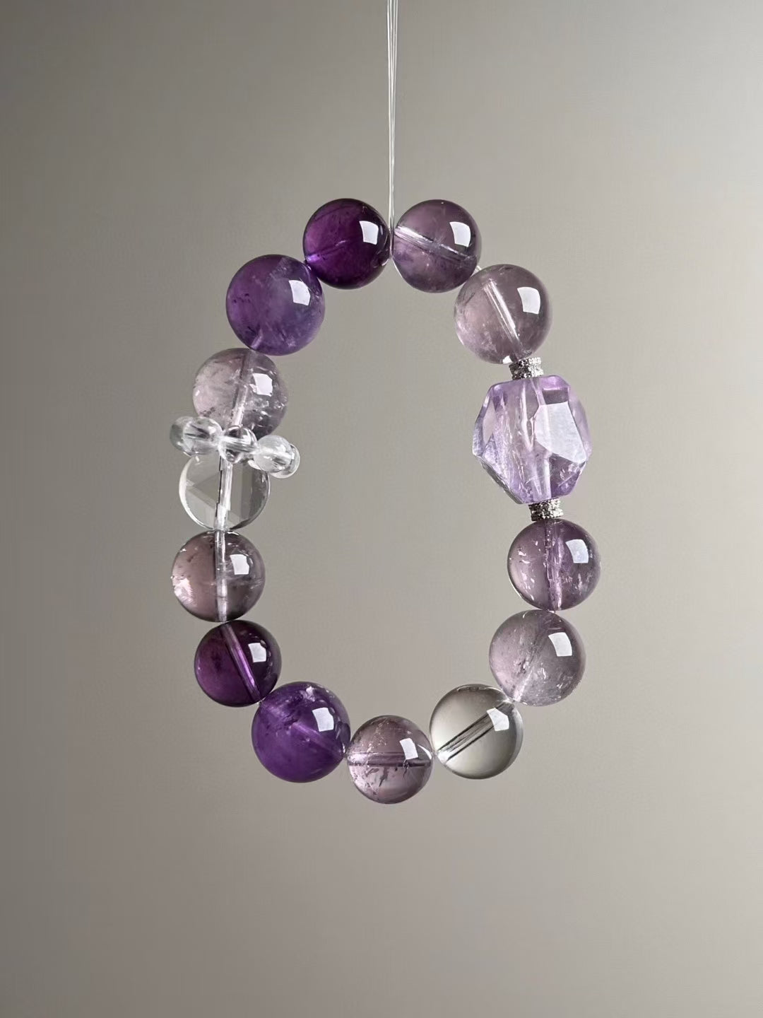 Detail — quartz runner cluster and high-clarity clear quartz sphere next to amethyst rounds