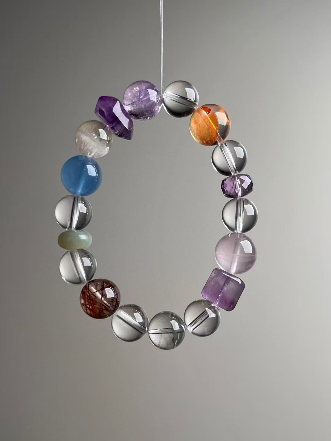Side angle — orange Citrine focal beside Clear Quartz and Amethyst; Aquamarine visible