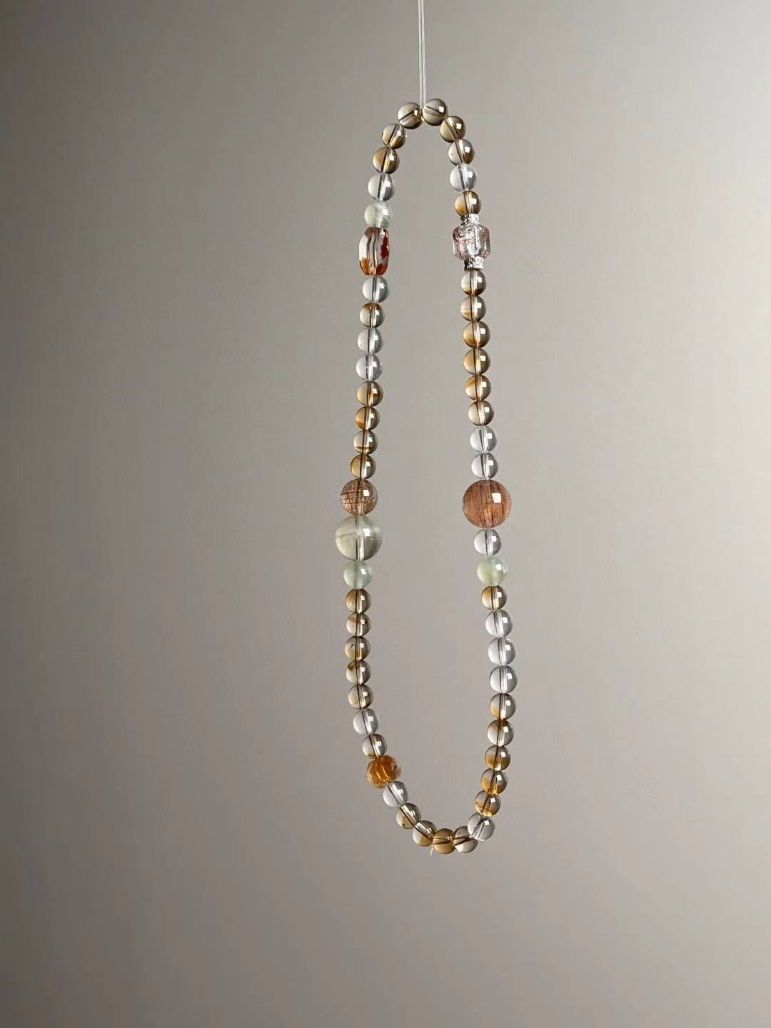 Side angle — close-up on copper rutile accents with Clear Quartz and green Prehnite rounds.