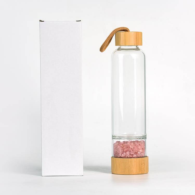 Single 450 ml bottle with rose-quartz chips beside minimal gift box packaging.