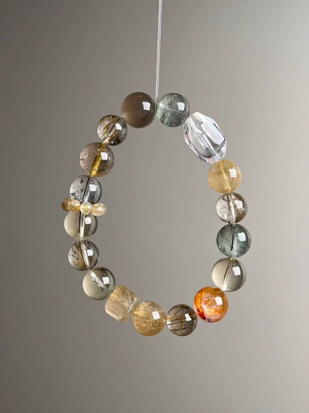 Front hero—Golden Matrix bracelet in mixed 12–10.5 mm beads: Gold Rutilated Quartz, White Phantom, Black-Gold Super Seven, Green Phantom, Grey Sunstone and Clear Quartz