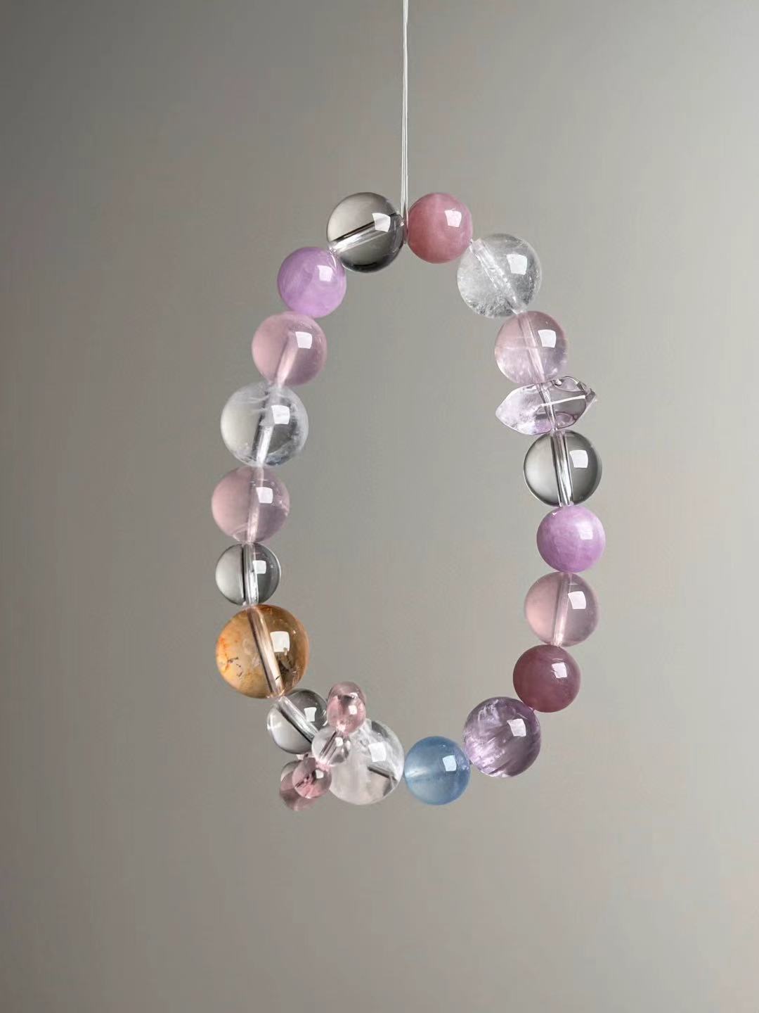 Macro texture—polished rose quartz, lepidolite, white azeztulite and clear quartz beads in 13–9 mm mix.