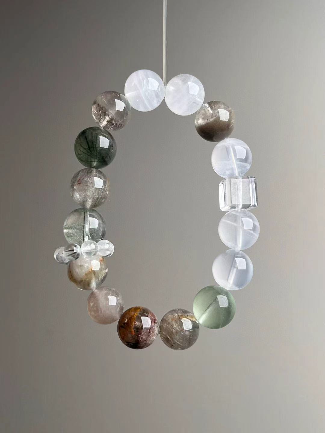 Angle view highlighting green fluorite glow and rutile needles within quartz.