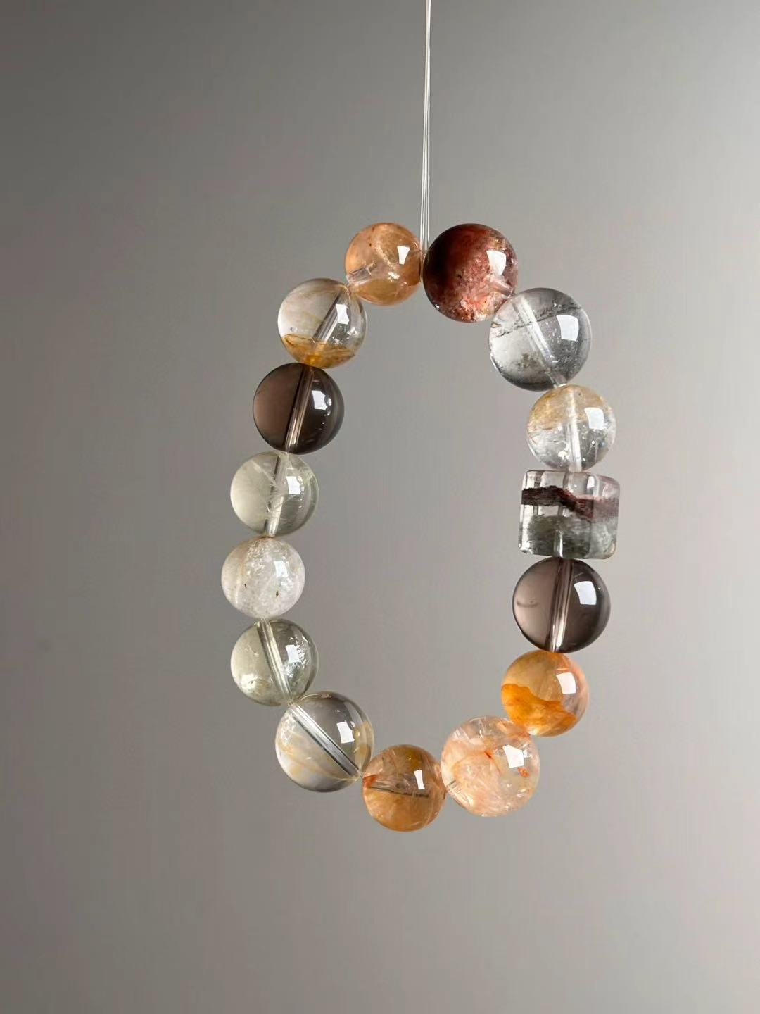 Macro texture—polished phantom quartz beads, Smoky Quartz, Yellow Azeztulite and the rainbow phantom cube