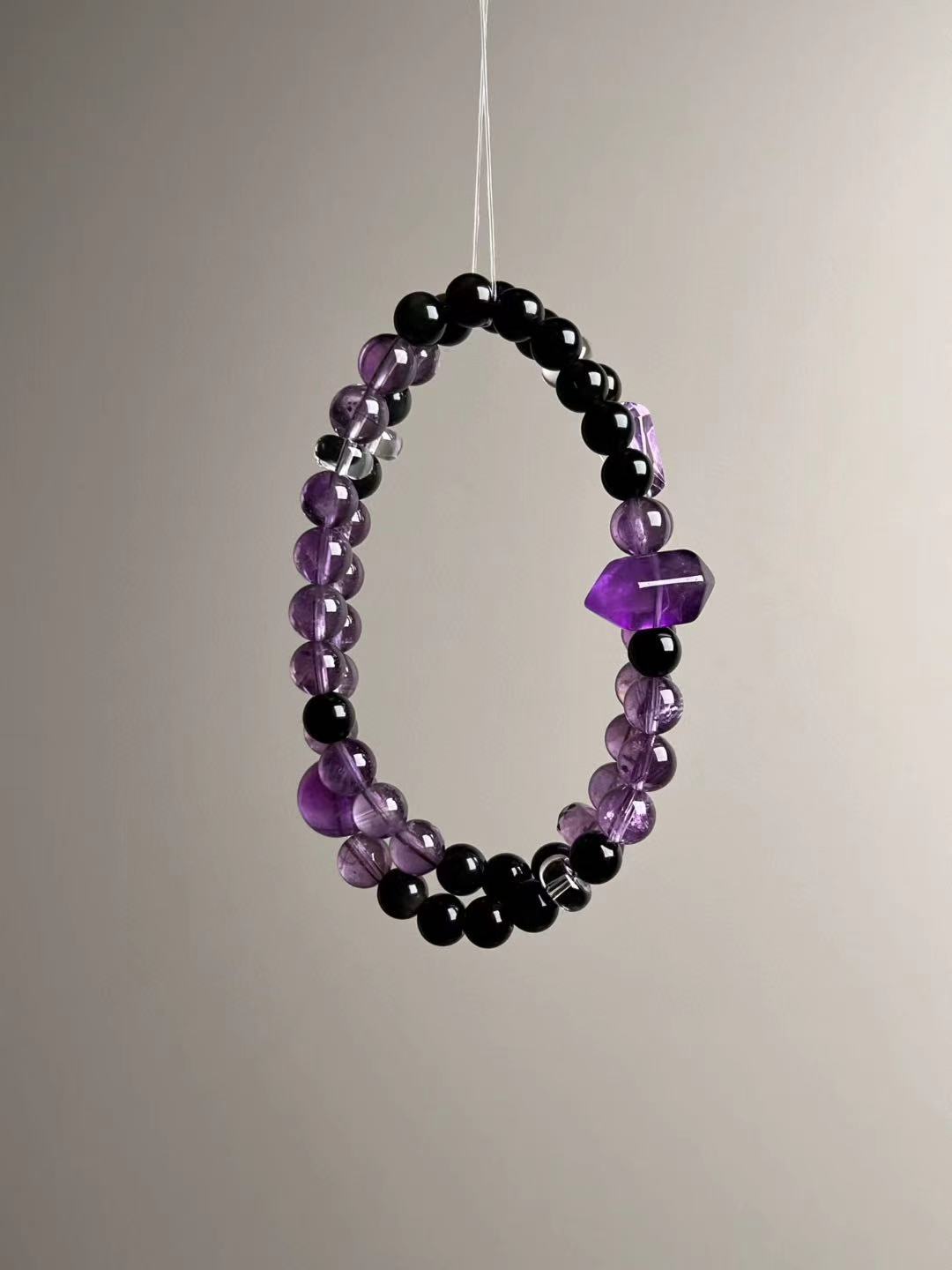 Three-quarter view of the wrapped bracelet emphasizing violet clarity and polished bead finish