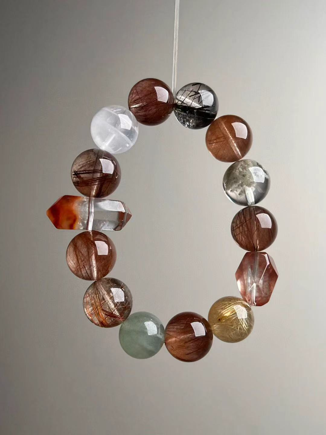 Close view of faceted and round beads on copper rutile master matrix bracelet — 13.5–14.5 mm