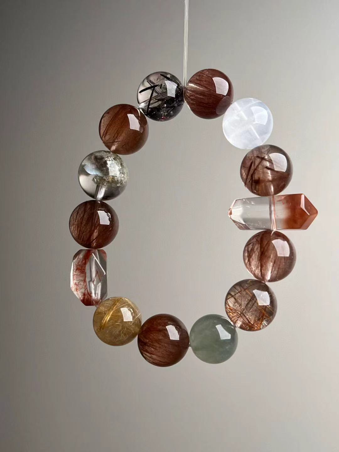 Side angle of copper rutile bracelet showing double-terminated red hair quartz focal bead