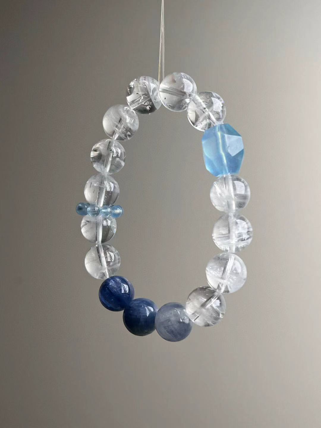 Side angle emphasizing the luminous aquamarine focal and crystal-clear quartz; airy, oceanic palette.