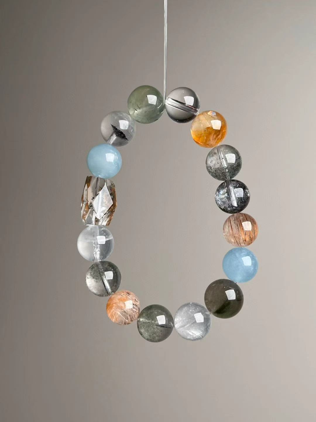 Prosperity Matrix bracelet hanging display with faceted garden quartz focal and golden rutile highlights.
