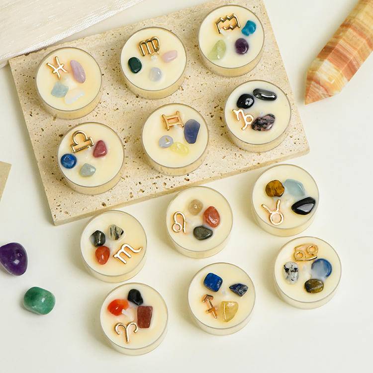 Top view of the full set of zodiac tea-light candles arranged on a tray with assorted gemstones and charms.