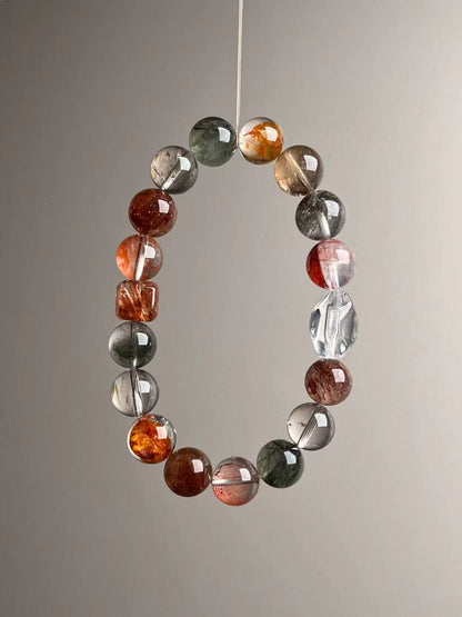 Close suspended circle capturing high-clarity segments and copper-red lepidocrocite beads; 10–11 mm polished rounds.