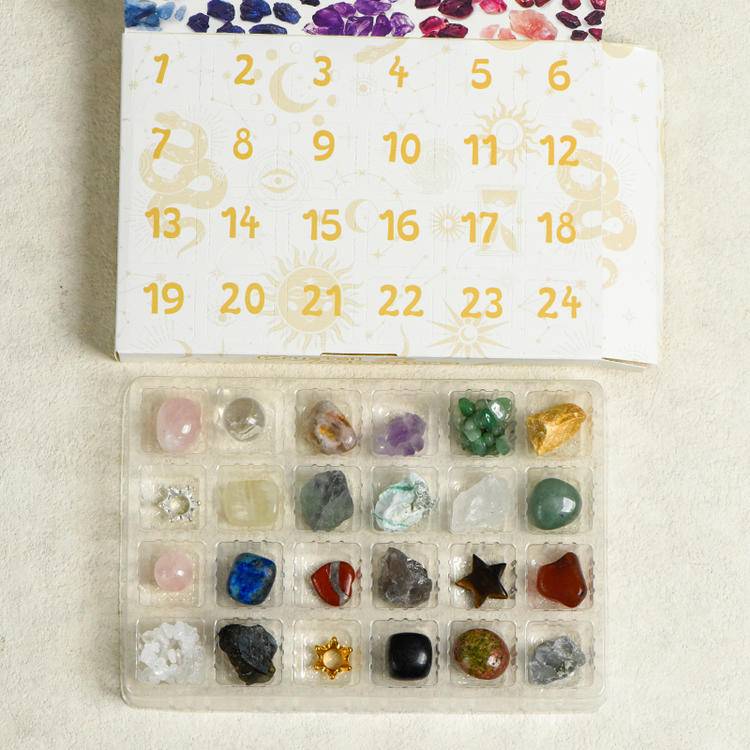 Advent-style box opened to reveal 24 compartments filled with assorted raw and tumbled crystals—ready for daily discovery.