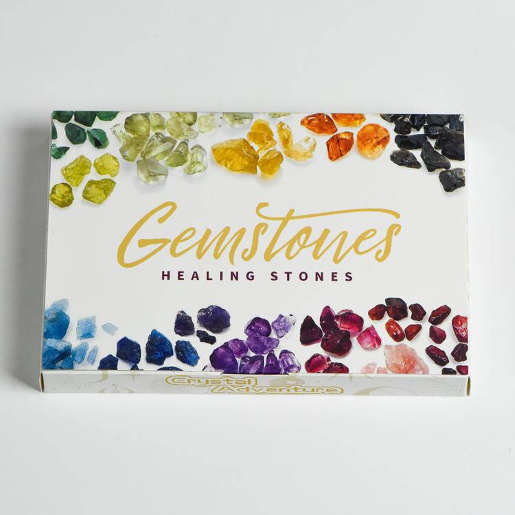 Top-down hero of the 24-piece raw & polished crystal blind box—rainbow gemstones framing the Gemstones Healing Stones cover.