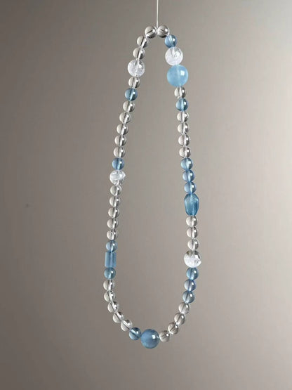 Angle view — aquamarine rounds and barrel accents with clear quartz micro rounds.