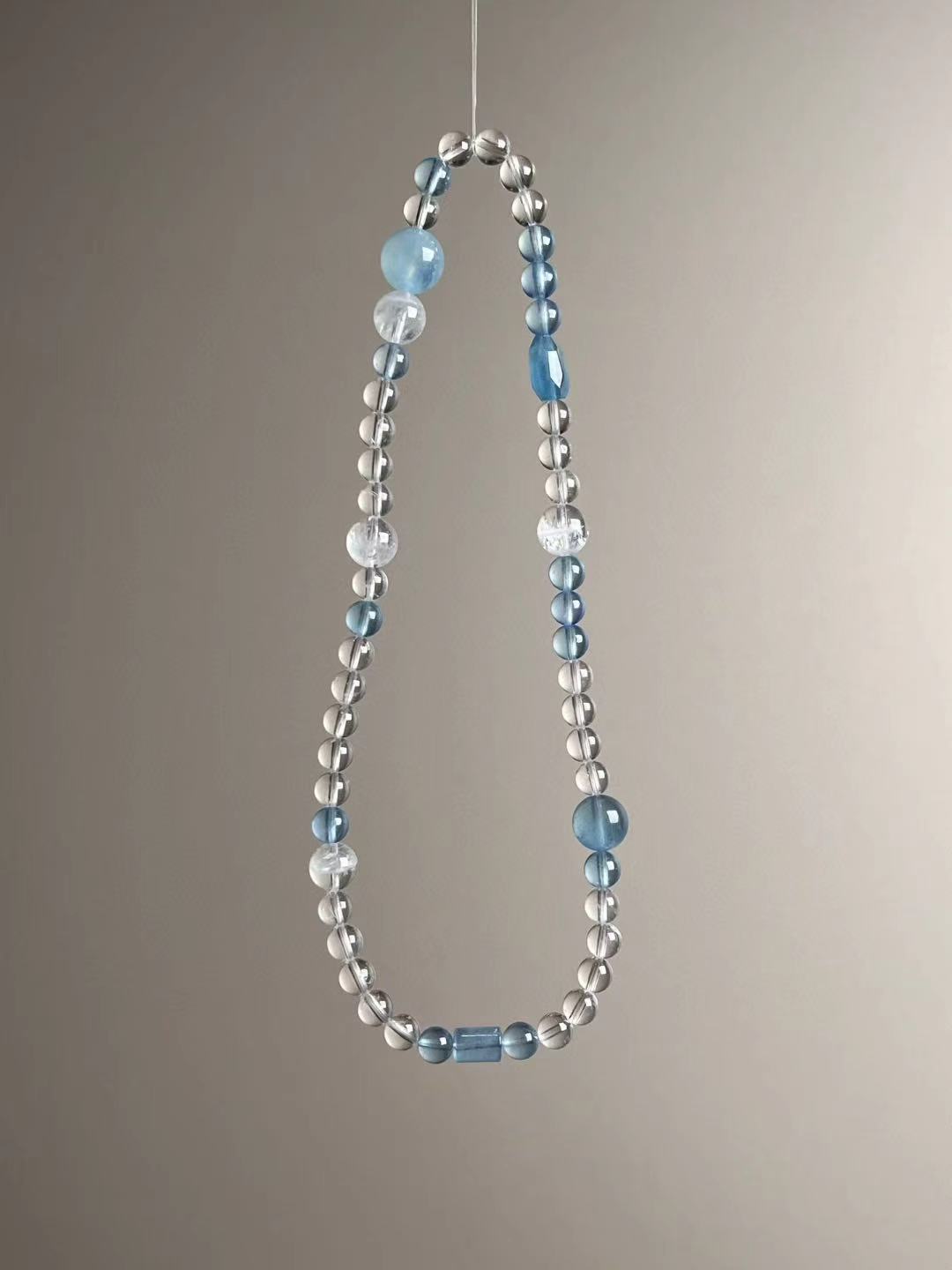 Full layout — slim triple-wrap strand featuring aquamarine, clear quartz and white phantom quartz.