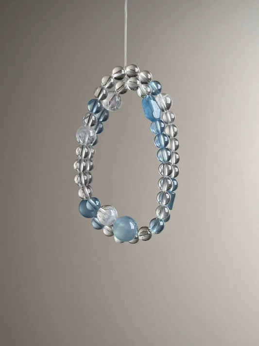 Side angle — faceted aquamarine centerpiece with white phantom accents and clear quartz.