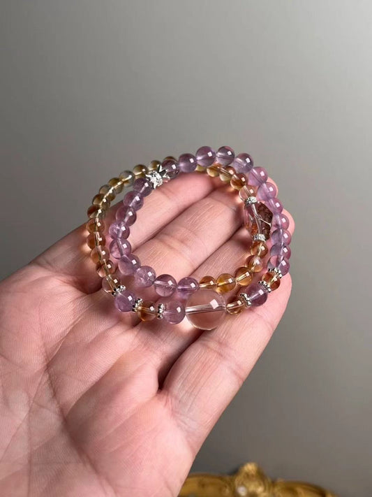 Hero — double-wrap bracelet of Amethyst, Citrine tower beads and Clear/Phantom Quartz; close-up on hand.