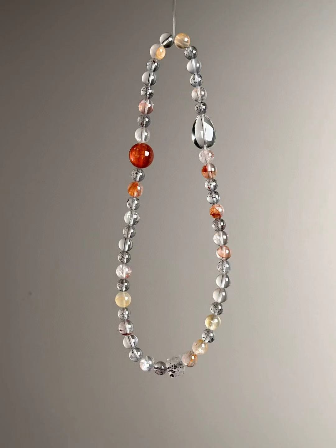 Detail — red and yellow Garden Quartz accents flanking a high-clarity Clear Quartz “orbit” cluster.