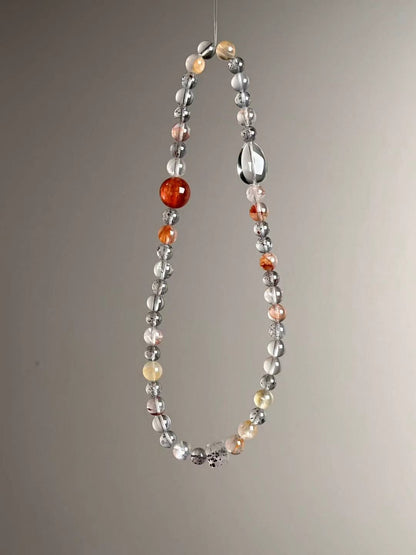 Detail — red and yellow Garden Quartz accents flanking a high-clarity Clear Quartz “orbit” cluster.