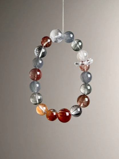 Catalog composite — gemstone callouts for Black Super Seven, Blue Rutilated Quartz, Green/White Phantom, Copper Rutilated Quartz, Goldstone, Koi Flower quartz and Gray Hair Quartz.