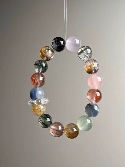 Full circle layout — Starry Goldsand bead, Rose Quartz, Green Phantom Quartz, Golden Rutile, Prehnite and Kyanite arranged around the strand.