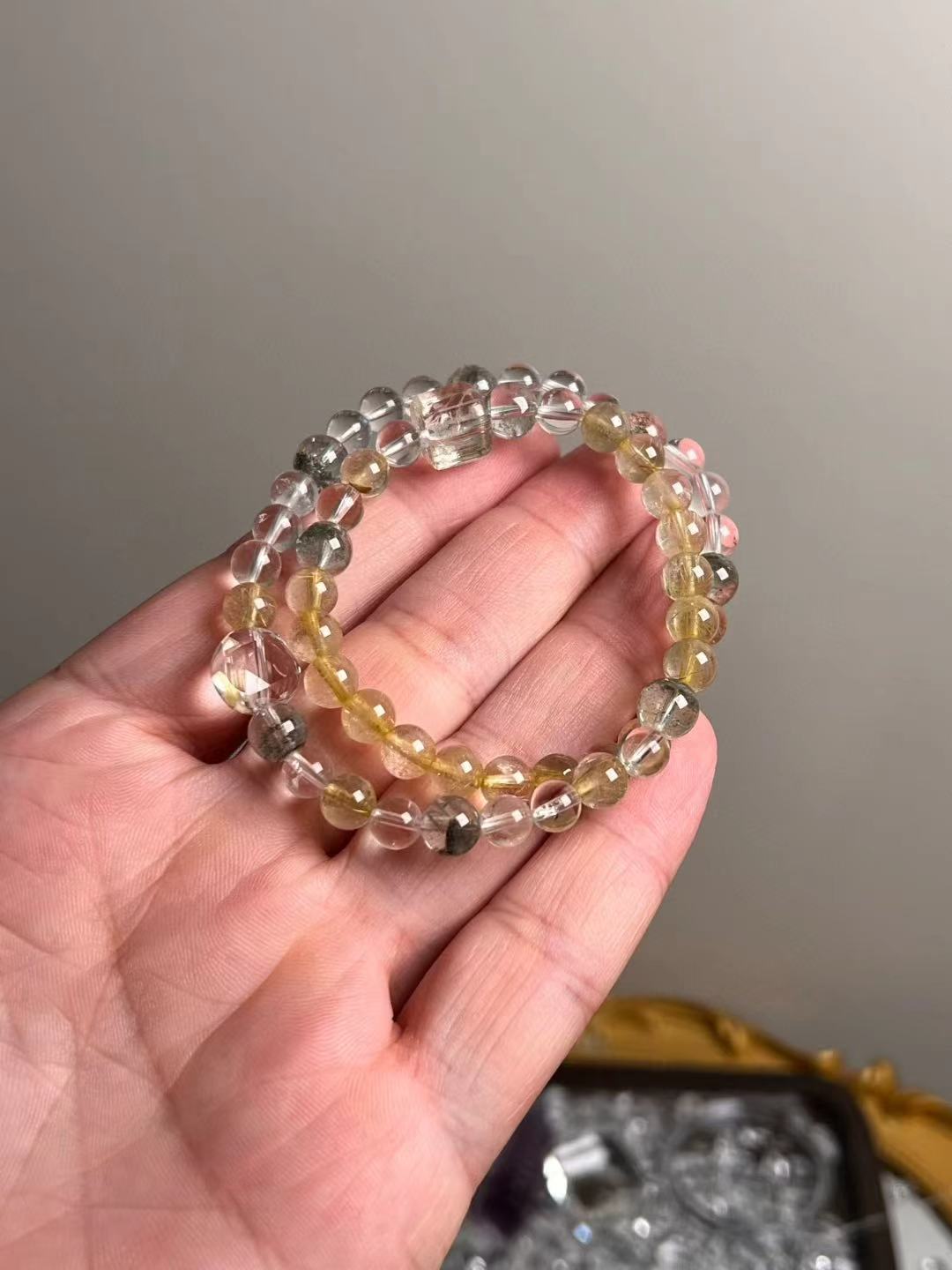 Hero view — 7 mm Golden Rutile Quartz, Clear Quartz and Green Phantom bracelet on hand.