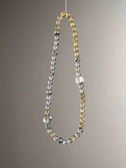 Detail layout — Clear Quartz cube accent with Golden Rutile and Green Phantom rounds.