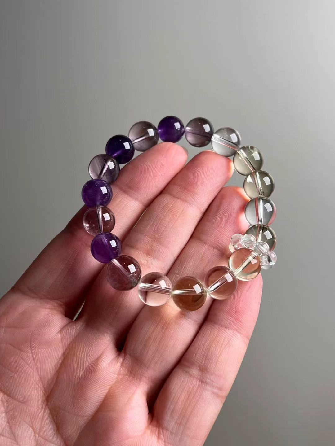 Hero view — Amethyst, Citrine and Clear Quartz bracelet, ~11–11.5 mm rounds with clear quartz mini-cluster accent.