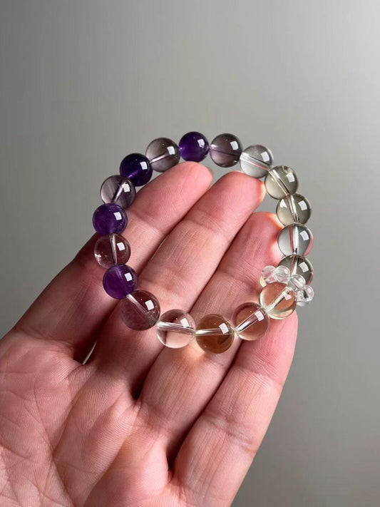 Hero view — Amethyst, Citrine and Clear Quartz bracelet, ~11–11.5 mm rounds with clear quartz mini-cluster accent.