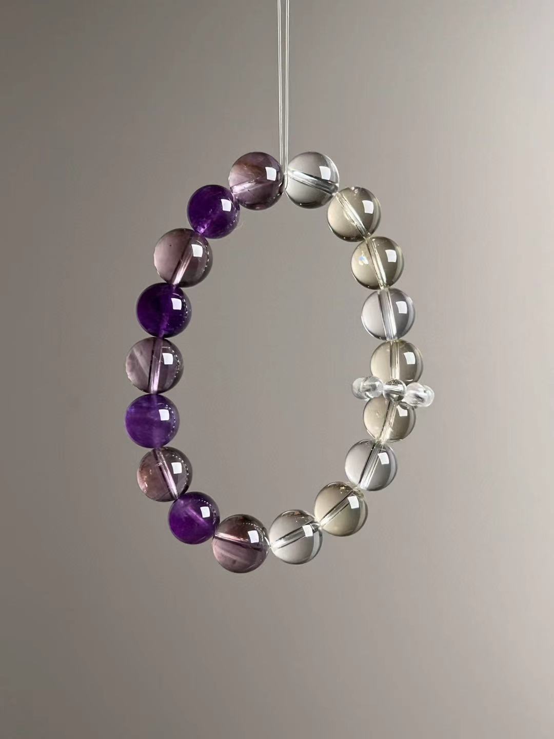 Side angle — balanced trio of Amethyst (purple), Citrine (gold), and Clear Quartz (transparent).