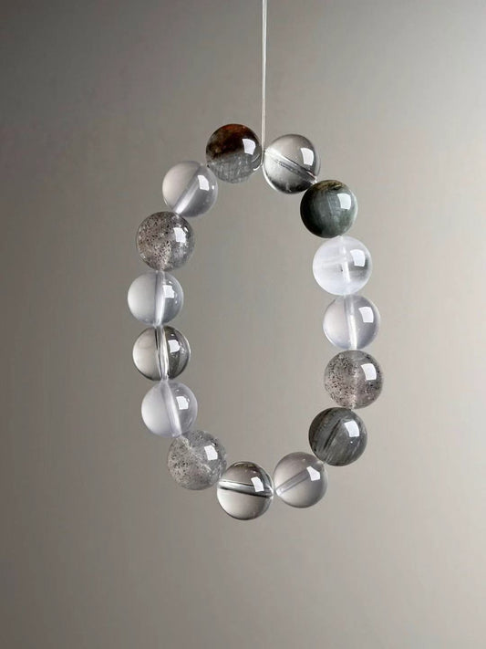 Close look at amphibole “rainbow hair” quartz and dark strawberry-like flecks within hematite-included quartz beads.