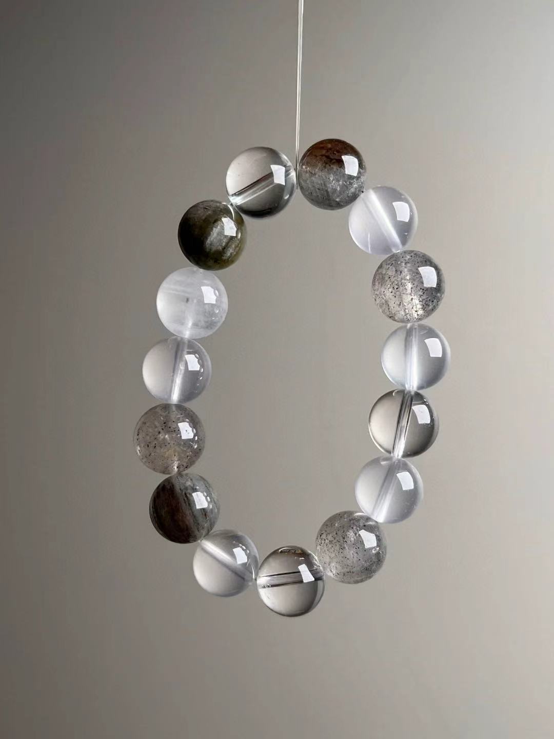 Balanced layout—clear quartz spacers, soft white milky quartz, grey-green phantom tones; Signature 13–12 mm mix.
