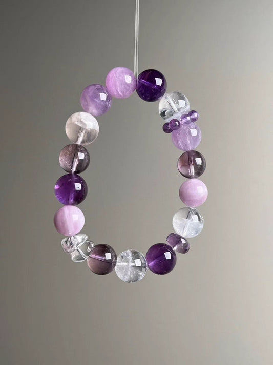 Angled hero—12.5–11.5 mm bracelet with Amethyst, White Phantom Quartz, Clear Quartz and Lepidolite; purple bead-cluster spacer