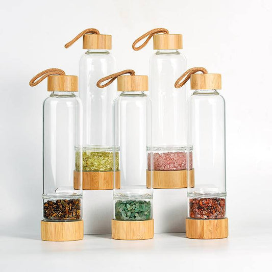 Group hero of 450 ml crystal-infusion glass bottles with bamboo lids and removable gem chambers—assorted stones.