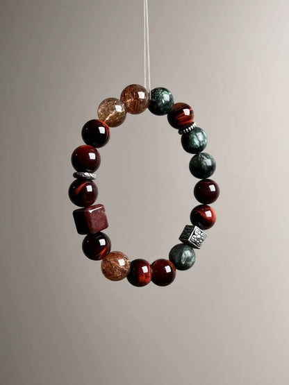 Front loop view highlighting chatoyant red tiger’s eye rounds with golden-rutile Super Seven and deep green seraphinite.