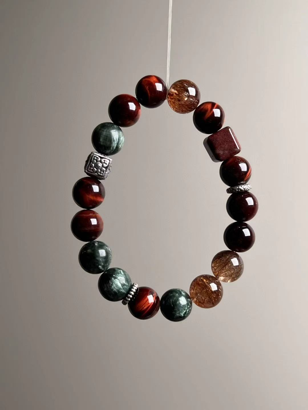 Three-quarter composition—mixed stones arranged in a modern cadence; ~10.5 mm polished rounds.
