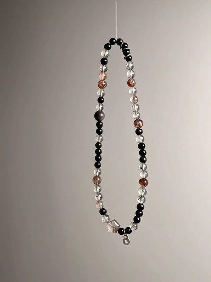 Three-quarter view emphasizing warm rutile-like threads within Super Seven and the polished obsidian contrast.