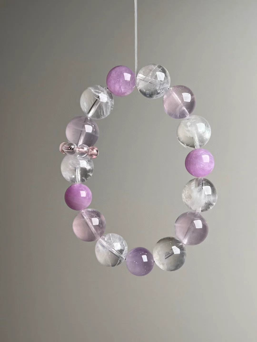 Front hero—Rose Quartz, White Phantom Quartz and Lepidolite 14–11 mm bracelet on grey background