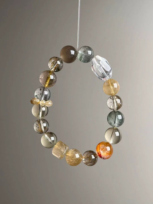Front hero—Golden Matrix bracelet in mixed 12–10.5 mm beads: Gold Rutilated Quartz, White Phantom, Black-Gold Super Seven, Green Phantom, Grey Sunstone and Clear Quartz