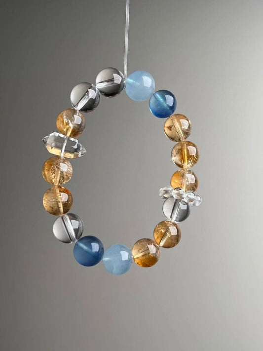 Angled view showing blue aquamarine beads, yellow azeztulite beads and clear quartz spacers, 12 mm size
