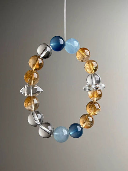 On-hand photo—12 mm Aquamarine, Yellow Azeztulite and Clear Quartz bracelet featuring double-terminated quartz and bead cluster spacer.