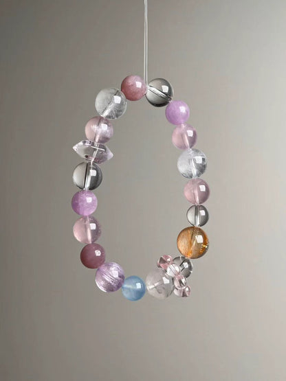 Angled hero view showing pink rose quartz, lilac lepidolite, white azeztulite and clear quartz beads with pink bead-cluster spacer