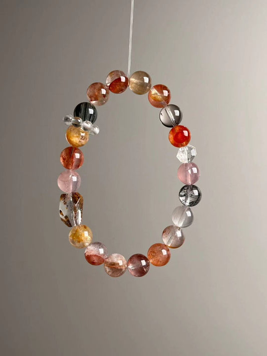 Angled hero—mix of translucent rose and amber tones; visible rutile needles and clear spacer cluster
