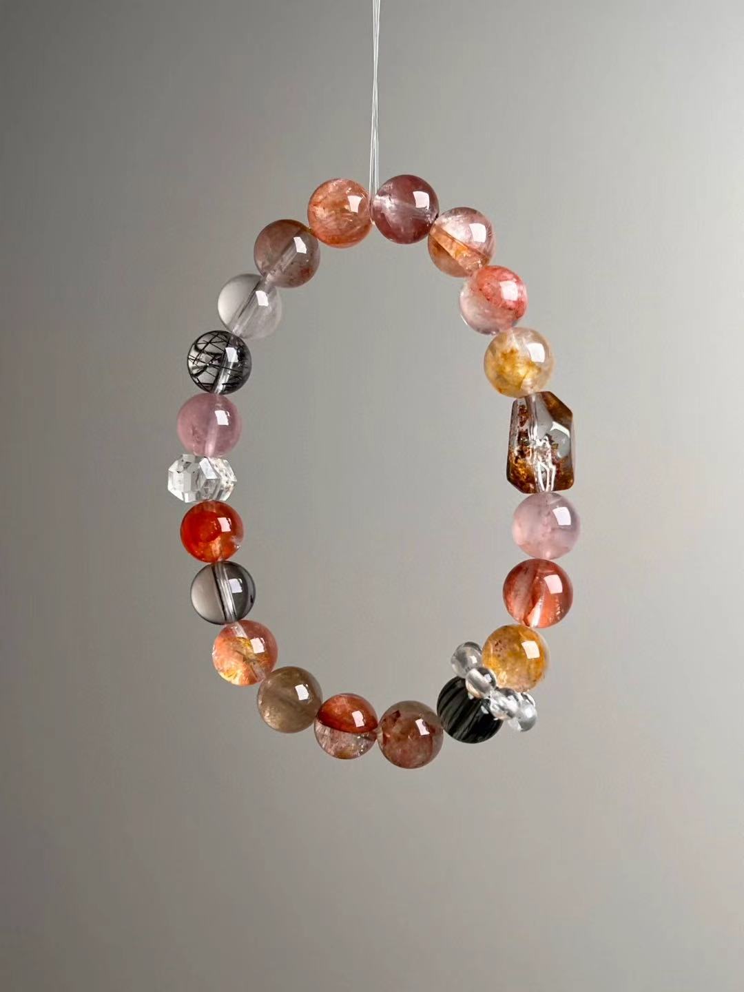 Angled hero—warm spectrum reds/yellows with Black Rutilated Quartz contrast and clear cluster spacer